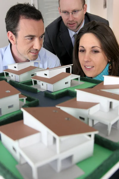 Архитектор, показывающий покупателям масштабную модель дома — стоковое фото