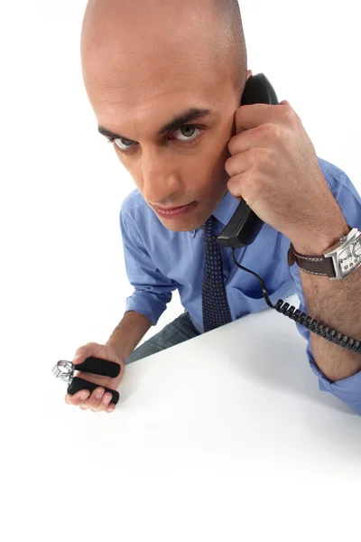 Civil servant squeezing hand grippers while talking on the phone — Stock Photo, Image