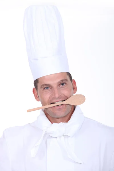 Férfi szakács egy fakanállal a szájban — Stock Fotó
