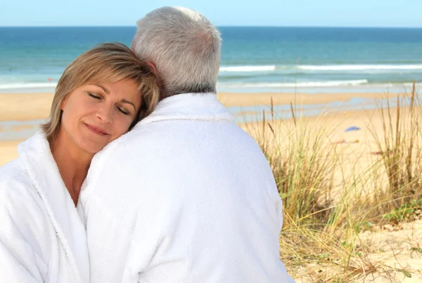 Ältere Paare im Bademantel am Strand — Stockfoto