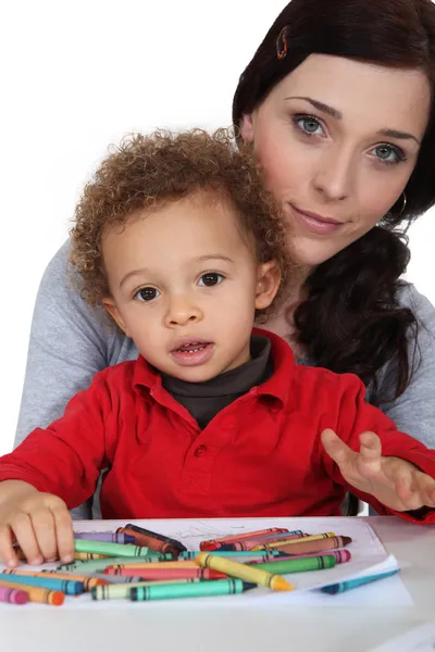 Retrato de jovem mãe com desenho de criança mestiça com palitos de cera — Fotografia de Stock