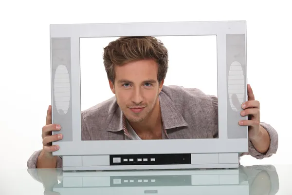 Young man smiling inside the frame of a TV set — Stock Photo, Image