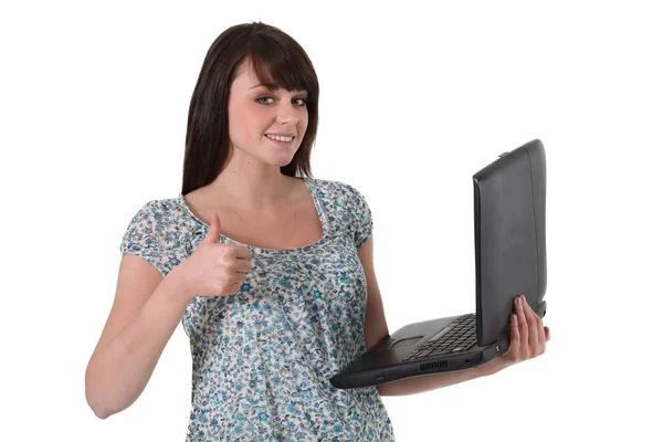 Morena sosteniendo ordenador portátil y dando los pulgares hacia arriba — Foto de Stock