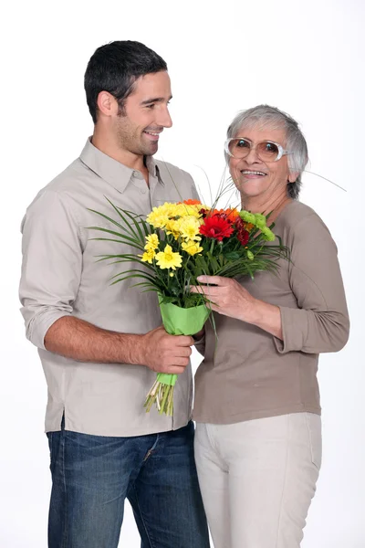Сын дарит матери цветы — стоковое фото