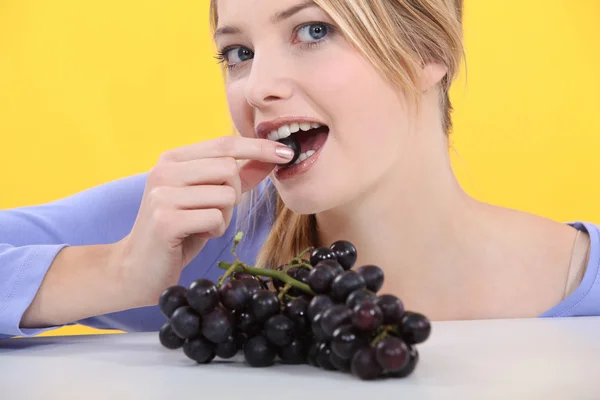 Donna attraente mangiare uva — Foto Stock