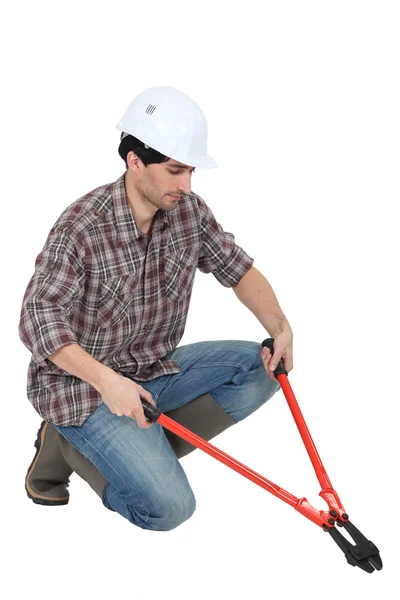 Man kneeling with bolt-cutters — Stock Photo, Image