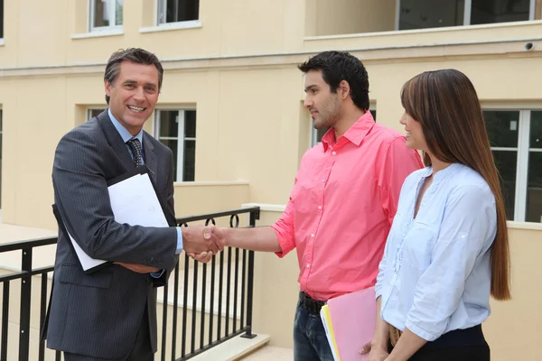 Couple serrant la main d'un agent immobilier — Photo