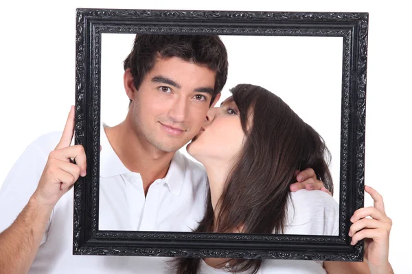 Νεαρό ζευγάρι φιλί σε ένα πλαίσιο — Φωτογραφία Αρχείου
