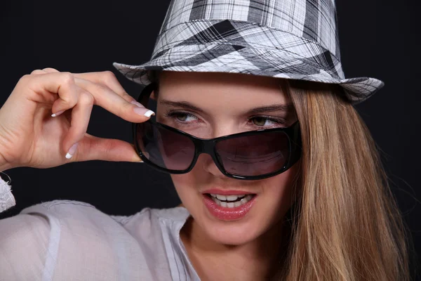Vrouw met glazen opstijgen haar hoed — Stockfoto