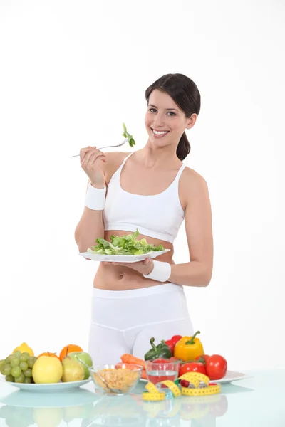 Frau isst einen Teller mit Salatblättern — Stockfoto