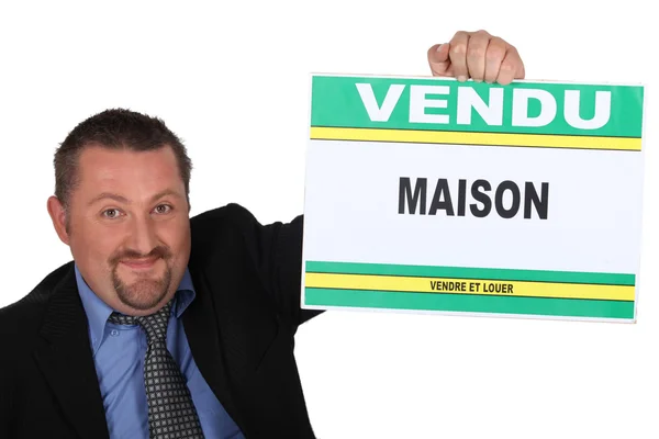 Agente inmobiliario con un cartel de 'Vendu' — Foto de Stock