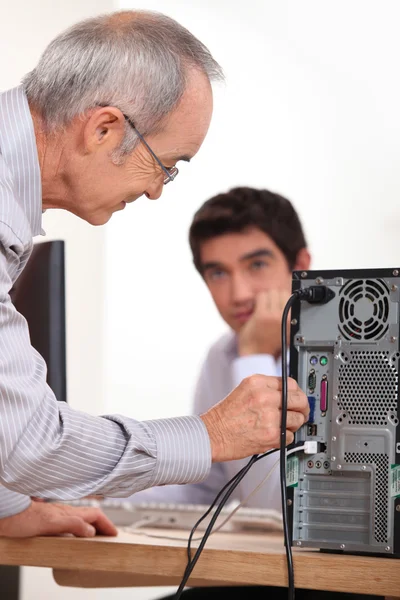 Man plugging a cable into the back of a hard drive — Stock Photo, Image