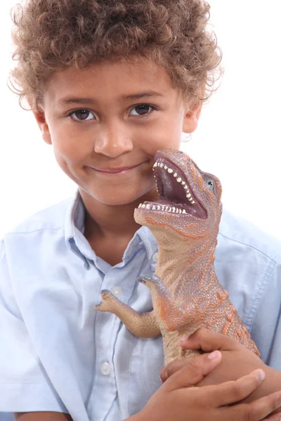 Мальчик играет с игрушечным динозавром — стоковое фото