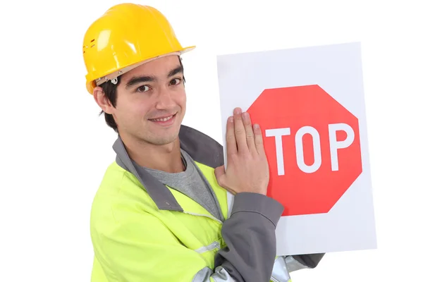 Young bricklayer wearing safety jacket and stop sign — Stock Photo, Image