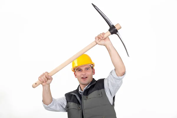 Laborer carrying pickaxe — Stock Photo, Image