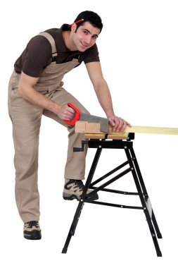 Male carpenter sawing. clipart