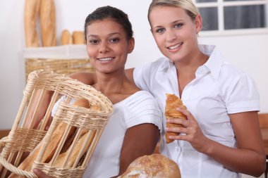 Two young women working in a bakery clipart