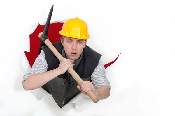 Worker bursting through with a pickaxe — Stock Photo, Image