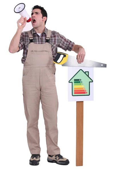 Hombre soplando en un megáfono y sosteniendo una sierra sobre una tabla de eficiencia energética —  Fotos de Stock
