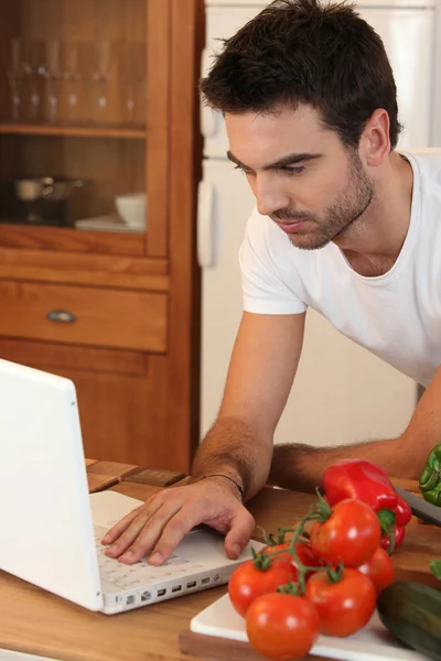 Человек ищет рецепт в Интернете — стоковое фото