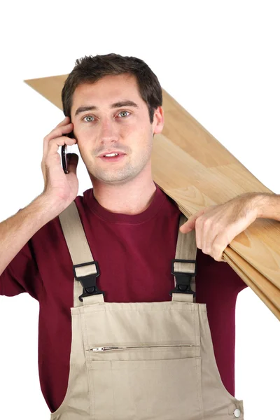 Arbeiter, der Bretter aus Holz trägt — Stockfoto