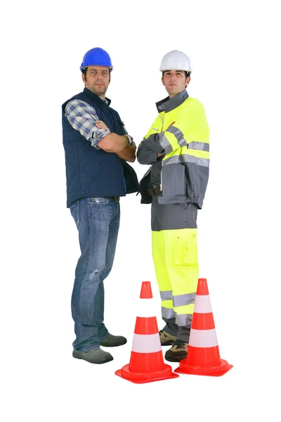 Dva silniční pracovníků stála dopravní kužely — Stock fotografie
