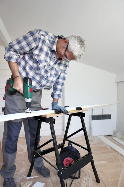 Hombre usando taladro eléctrico en tablón de madera —  Fotos de Stock
