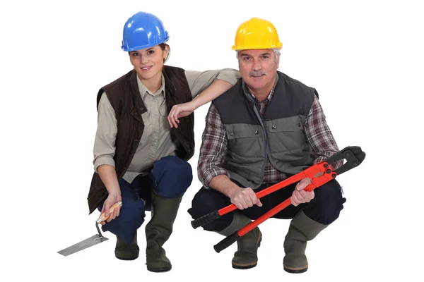 Dois trabalhadores da construção ajoelhados . — Fotografia de Stock