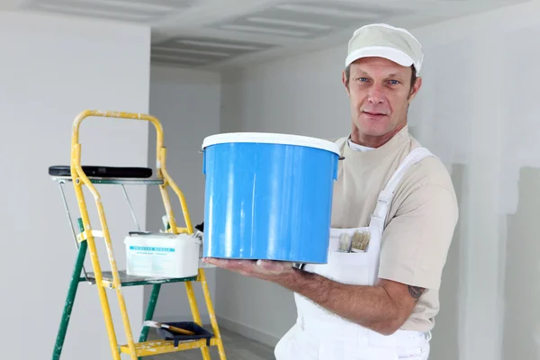 Maler hält eine Dose Farbe in der Hand — Stockfoto