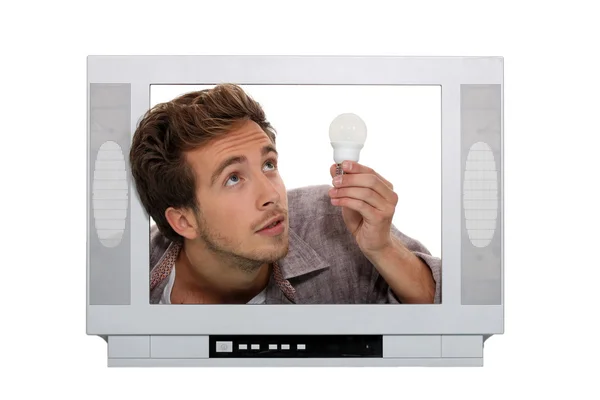 Homem na televisão com uma lâmpada — Fotografia de Stock