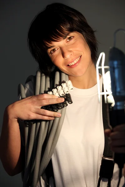 Vrouwelijke elektricien verlicht door een lamp — Stockfoto