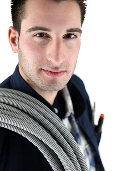 Tradesman carregando tubulação ondulada em torno de seu ombro — Fotografia de Stock