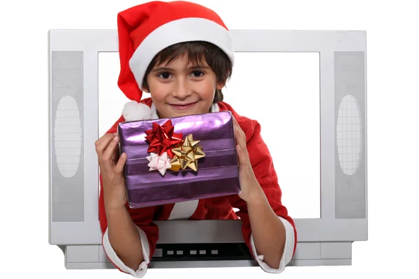 Menino vestido de Papai Noel escapando do aparelho de televisão — Fotografia de Stock