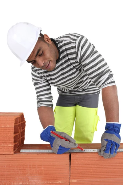 A bricklayer using a ruler — Stock Photo, Image