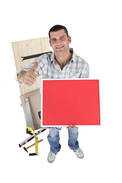 Handyman sosteniendo un cartel rojo — Foto de Stock