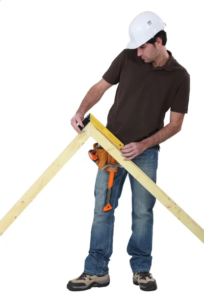 Trabalhador usando uma régua de ângulo reto para medir um ângulo — Fotografia de Stock