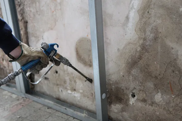 Homem a pulverizar incrustações nas paredes — Fotografia de Stock