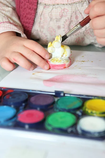 Little girl painting figurine — Stock Photo, Image