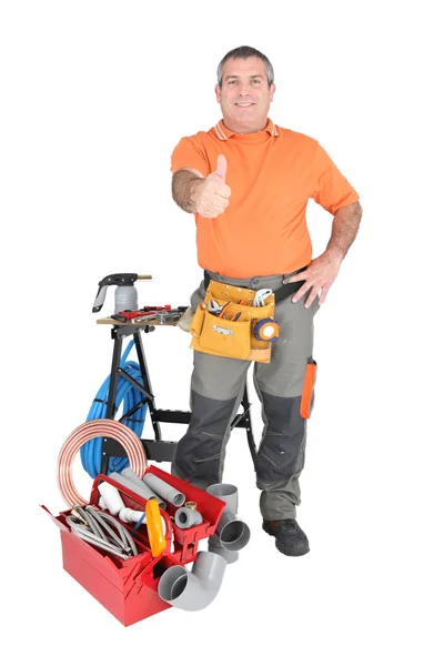 55 years old handyman doing thumbs up surrounded by a lot of tools and materials — Stock Photo, Image