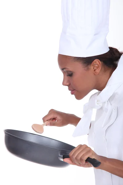 Kvinnliga kock i uniform under omrörning en icke teflonpanna — Stockfoto