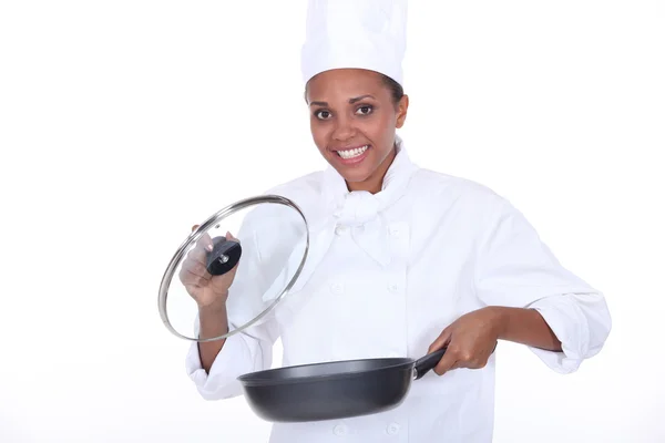 Female chef exhibits a frying pan — Stock Photo, Image