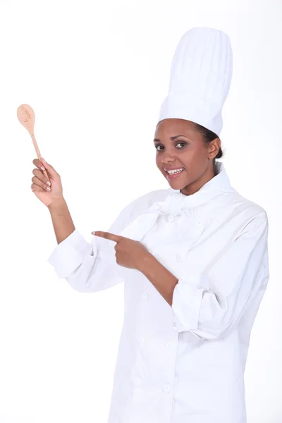 Studio shot of a female chef with a wooden spoon — Stock Photo, Image