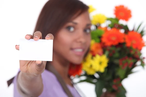 Молодой флорист показывает визитку — стоковое фото