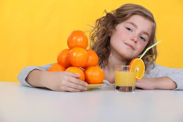 오렌지 주스 한 잔을 마시는 어린 소녀 — 스톡 사진