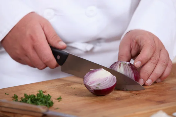 Koch schneidet eine rote Zwiebel — Stockfoto