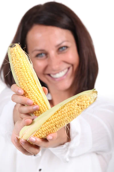 Mulher oferecendo duas espigas de milho doce — Fotografia de Stock