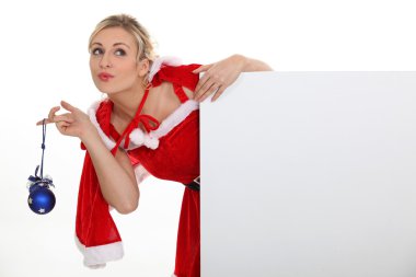 Woman dressed as Mrs. Claus and holding a blank board clipart