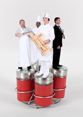 Workers of food and catering trade standing on giant salt cellar and pepperpot clipart