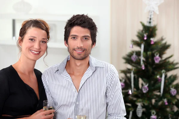 Couple posing in front of their Christmas tree — Stock Photo, Image
