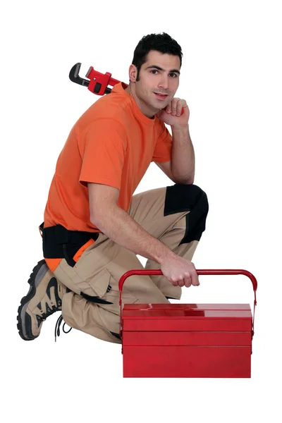 Arbeiter kniet an Werkzeugkiste — Stockfoto